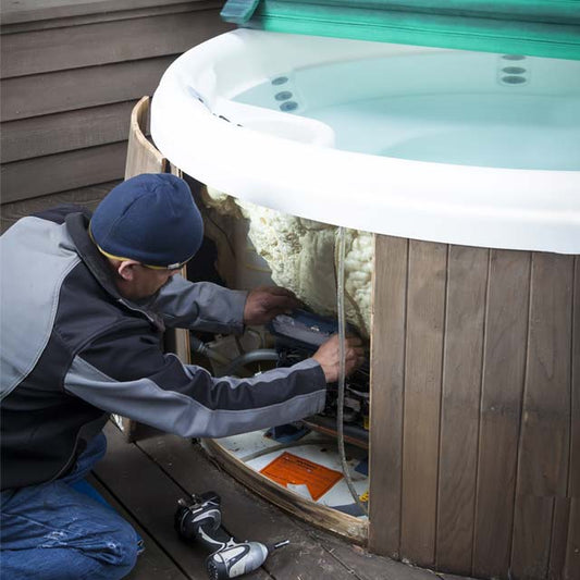 Man Inserting Spa Parts Into Hot Tub